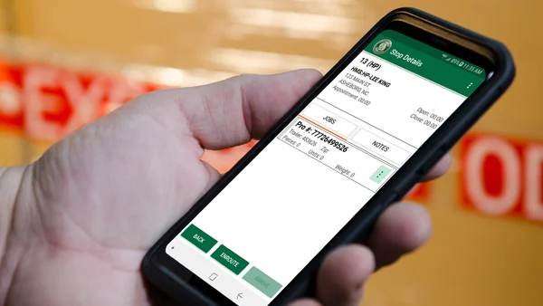 Holding a Mobile Device Tracking an Expedited Shipment