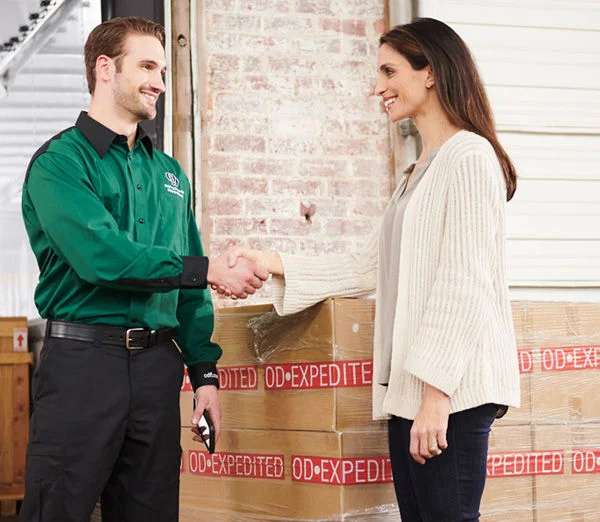 ODFL employee shaking hands with customer in front of expedited LTL freight delivery.